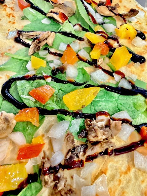 Savory crepe with spinach, mushrooms, peppers, onion, and balsamic glaze