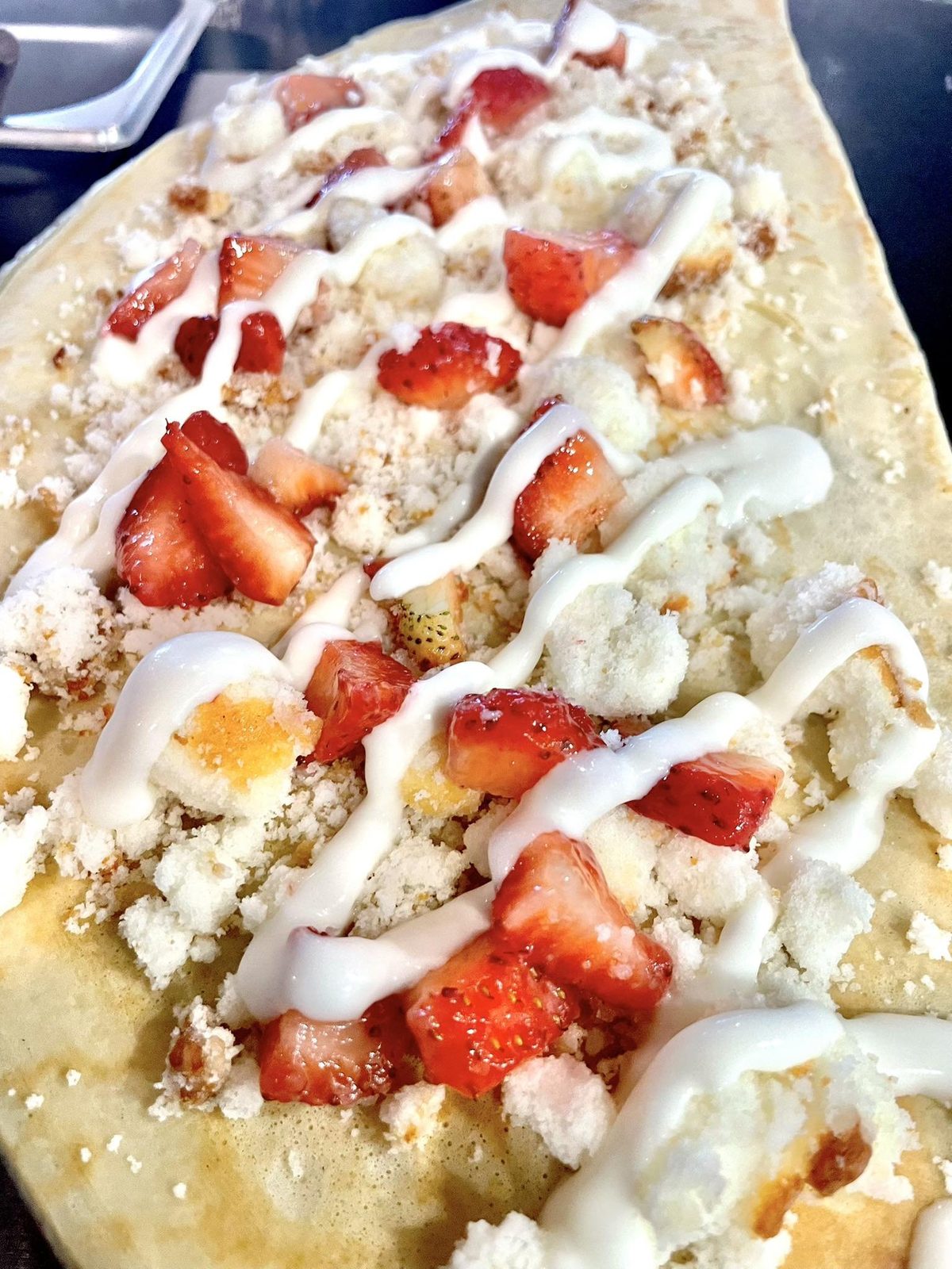 Sweet strawberry crepe with cream drizzle and fresh berries